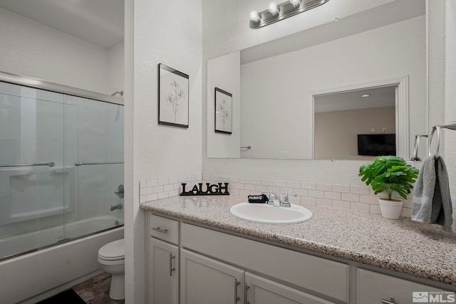 full bathroom featuring vanity, toilet, shower / bath combination with glass door, and decorative backsplash