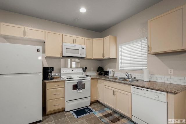 kitchen with sink, white appliances, and dark tile patterned floors