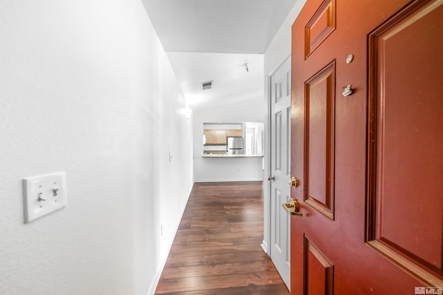 hallway featuring lofted ceiling and dark hardwood / wood-style flooring