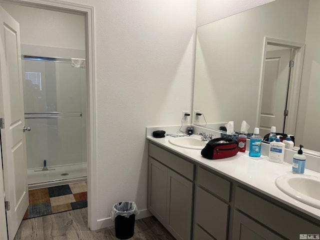 bathroom featuring vanity, hardwood / wood-style floors, and a shower with door