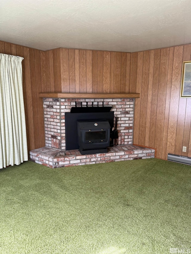 room details featuring wood walls, carpet, a textured ceiling, a baseboard radiator, and a wood stove