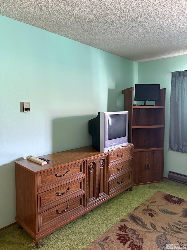 carpeted bedroom featuring a baseboard radiator and a textured ceiling