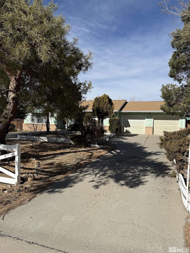 view of property hidden behind natural elements featuring a garage