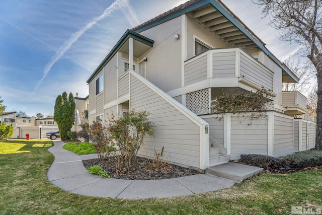 view of home's exterior featuring a yard and a balcony