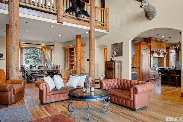 living room featuring a high ceiling and light wood-type flooring