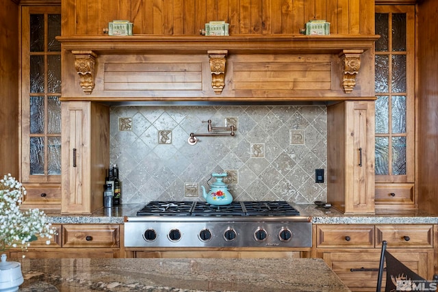 kitchen with stone countertops, stainless steel gas cooktop, and decorative backsplash