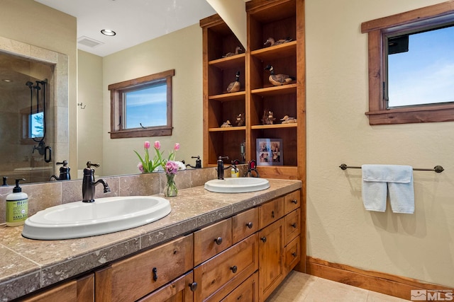 bathroom with vanity, an enclosed shower, tile patterned flooring, and plenty of natural light