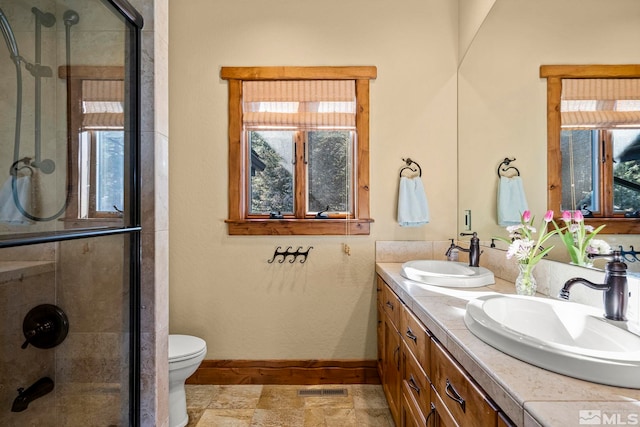 bathroom with walk in shower, vanity, and toilet