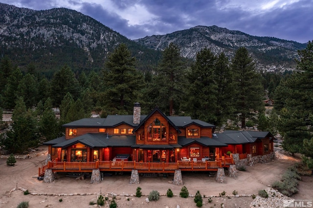 back house at dusk featuring a deck with mountain view