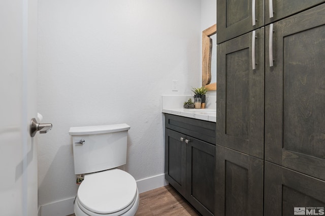 bathroom featuring vanity, wood-type flooring, and toilet