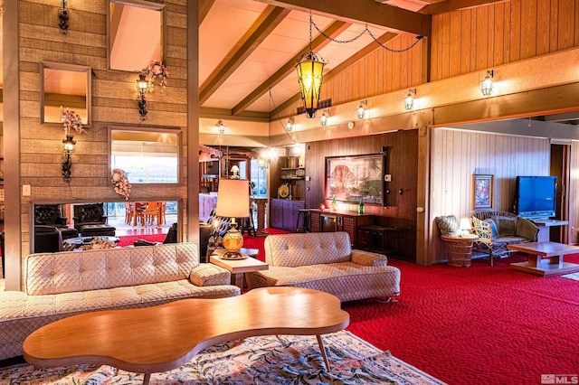 living room featuring carpet floors, beam ceiling, wooden walls, and high vaulted ceiling