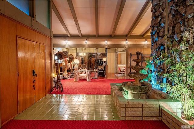 unfurnished living room featuring beamed ceiling, tile patterned floors, and wood walls