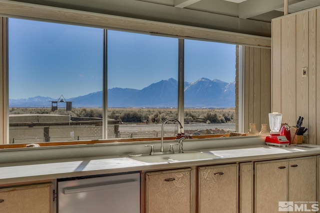 kitchen with light brown cabinetry, a mountain view, stainless steel dishwasher, and sink