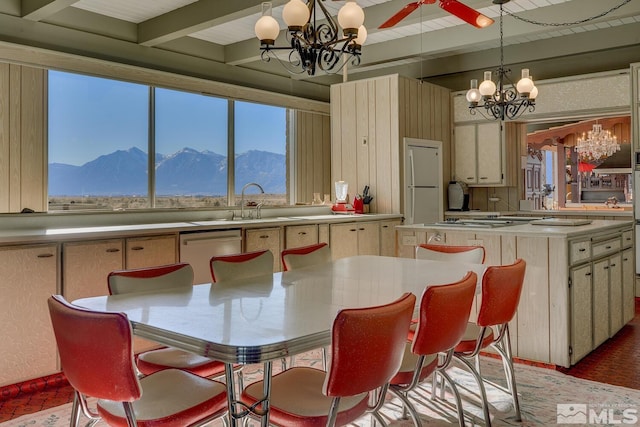 kitchen featuring a chandelier, stainless steel appliances, a mountain view, and beamed ceiling