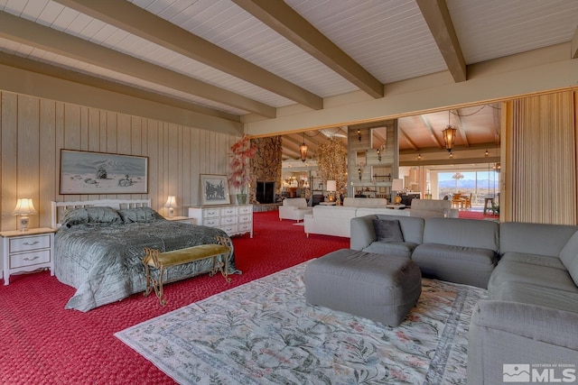 bedroom featuring a fireplace, beam ceiling, carpet floors, and wood walls