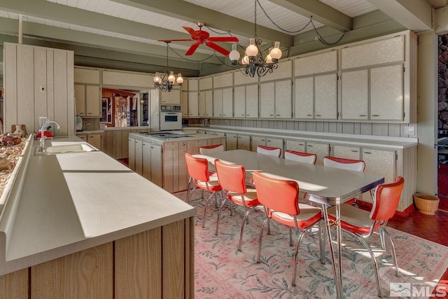 kitchen featuring a kitchen island, sink, a chandelier, hanging light fixtures, and white oven