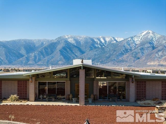 exterior space featuring a mountain view and a patio area