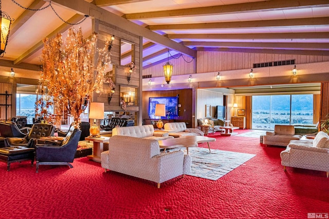 carpeted living room with beamed ceiling, high vaulted ceiling, and wood walls