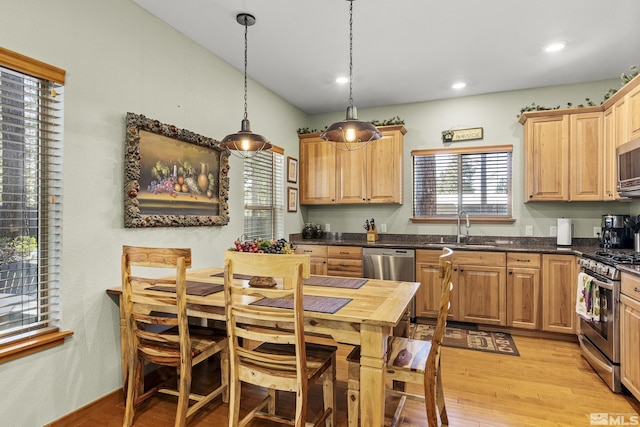 kitchen featuring pendant lighting, sink, light hardwood / wood-style floors, stainless steel appliances, and light brown cabinets