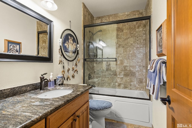 full bathroom featuring vanity, shower / bath combination with glass door, and toilet