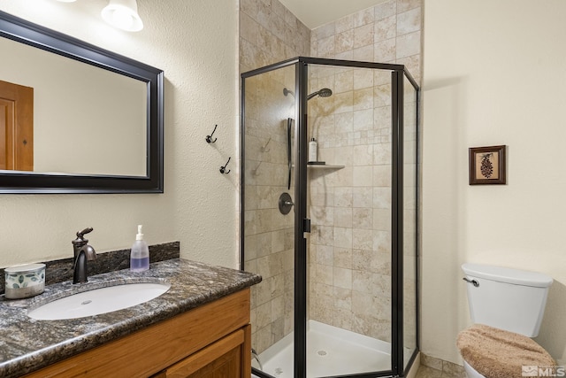 bathroom featuring vanity, toilet, and an enclosed shower