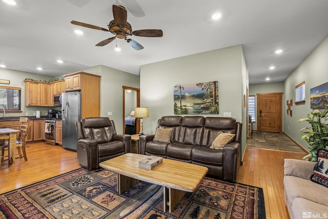 living room with ceiling fan and light hardwood / wood-style flooring