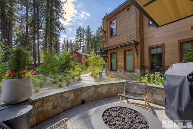 view of patio featuring an outdoor fire pit and a grill