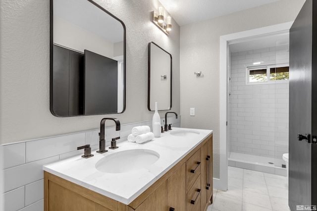 bathroom featuring vanity, toilet, and a tile shower