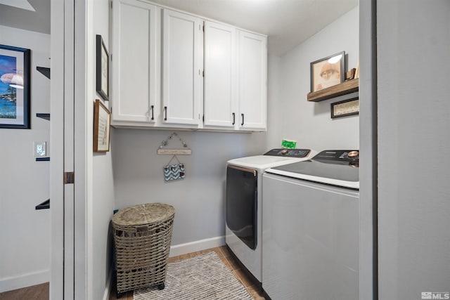 clothes washing area with hardwood / wood-style flooring, cabinets, and washer and clothes dryer