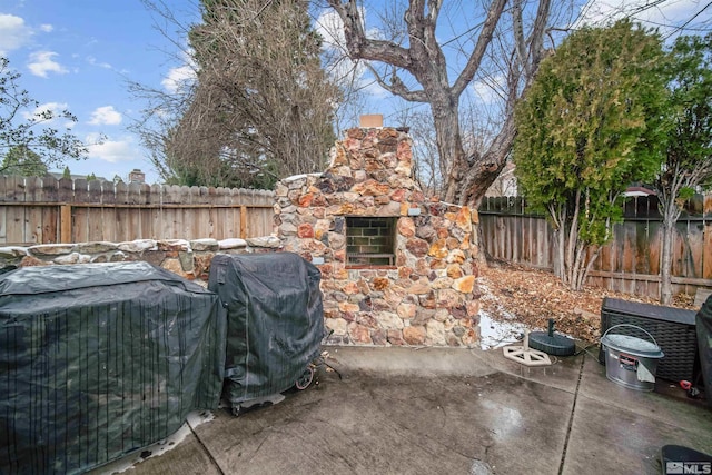 view of patio with area for grilling and an outdoor stone fireplace