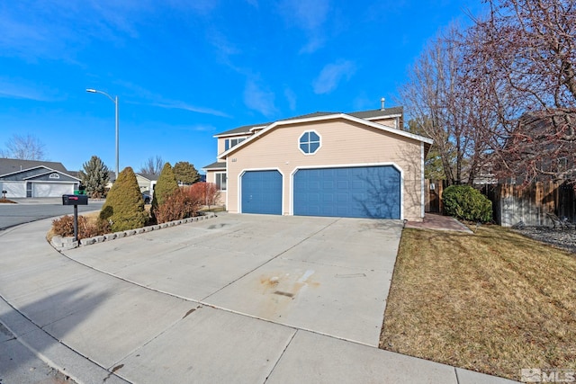 view of side of property featuring a garage and a lawn