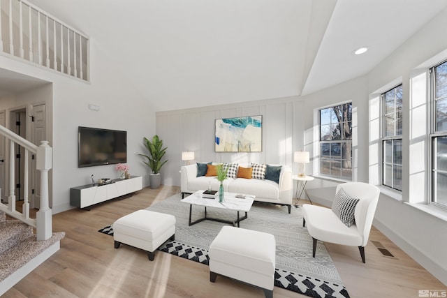 living room with hardwood / wood-style flooring and high vaulted ceiling