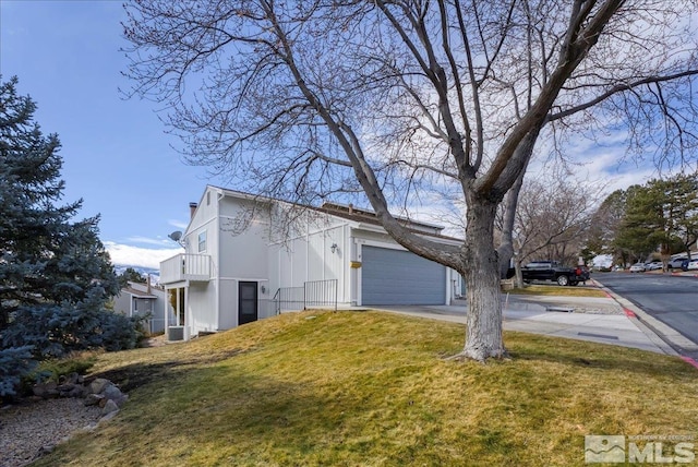 view of property exterior with a garage, a yard, and a balcony