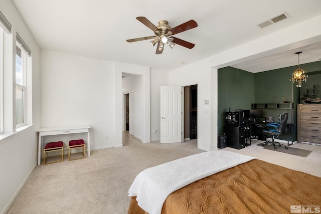 carpeted bedroom featuring ceiling fan with notable chandelier