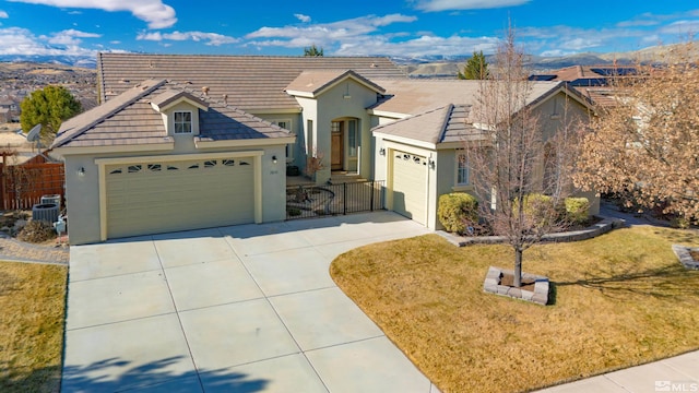 view of front of property with a mountain view, a garage, a front yard, and central air condition unit