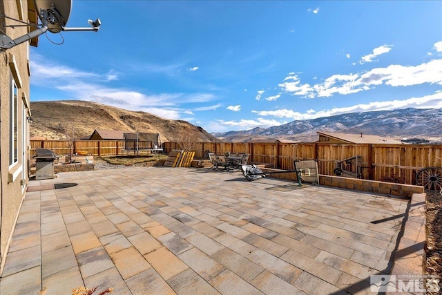 view of patio with grilling area and a mountain view