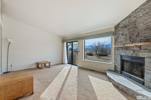 living room with a stone fireplace and light carpet