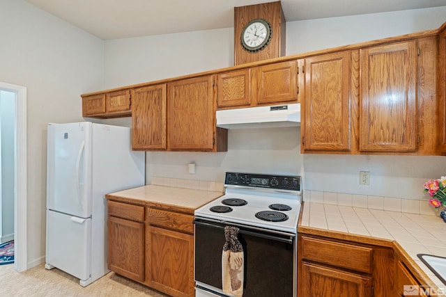 kitchen featuring white refrigerator, tile countertops, sink, and range with electric stovetop