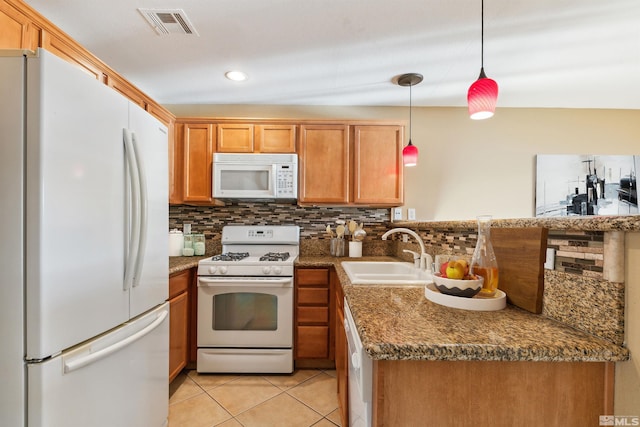 kitchen featuring pendant lighting, sink, white appliances, and tasteful backsplash
