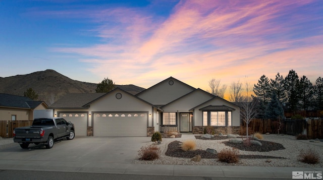 ranch-style home with a garage and a mountain view