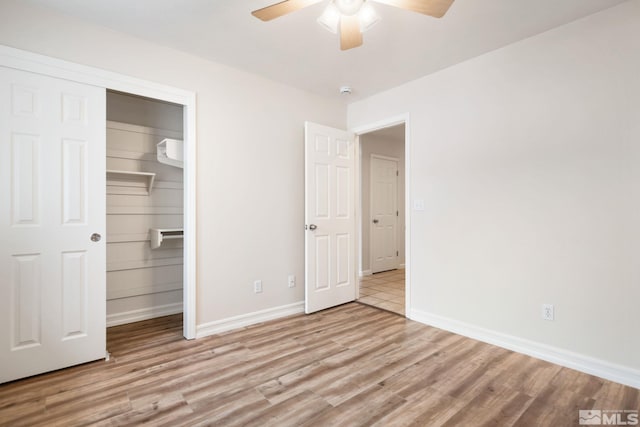 unfurnished bedroom with ceiling fan, light wood-type flooring, and a closet