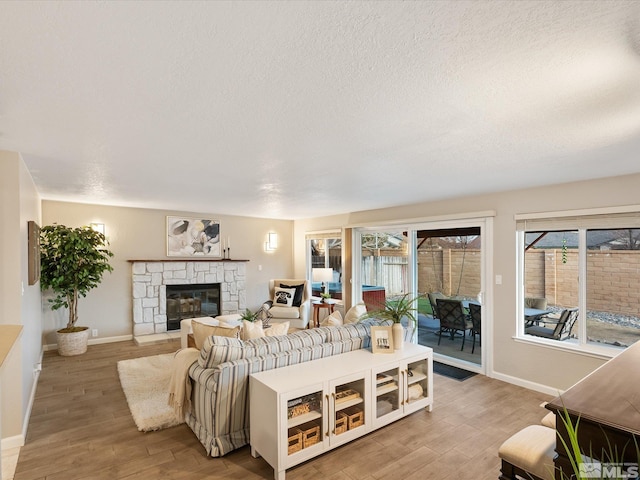 living room with hardwood / wood-style floors, a textured ceiling, and a fireplace