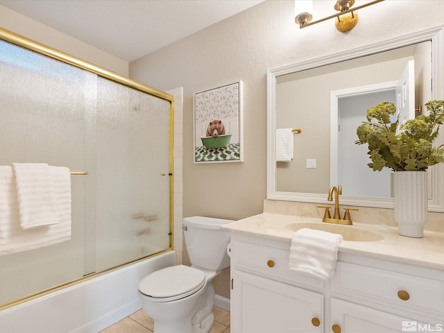 full bathroom featuring vanity, tile patterned floors, shower / bath combination with glass door, and toilet