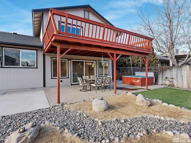 back of house featuring a hot tub, a deck, and a patio area