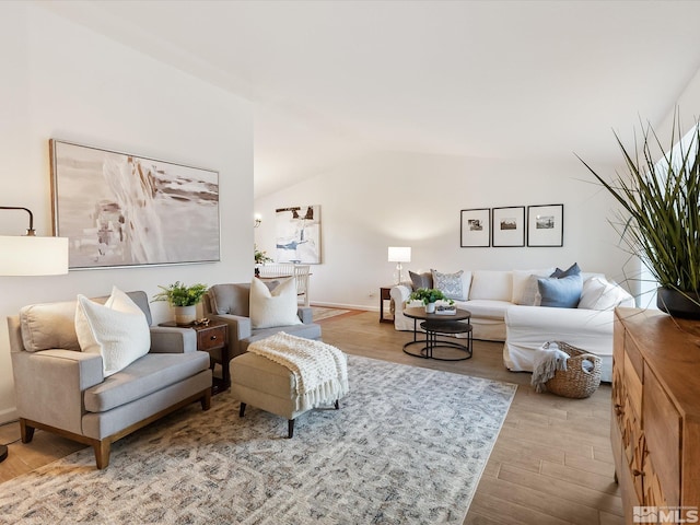 living room featuring lofted ceiling and light hardwood / wood-style flooring