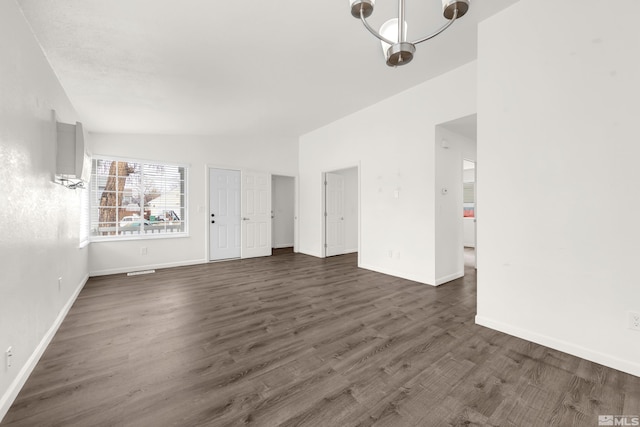 unfurnished room with vaulted ceiling and dark wood-type flooring