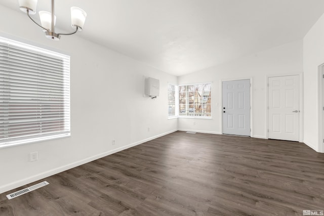 interior space with vaulted ceiling, a notable chandelier, and dark hardwood / wood-style flooring