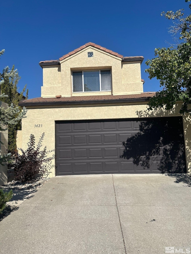 view of front facade featuring an attached garage, concrete driveway, and stucco siding
