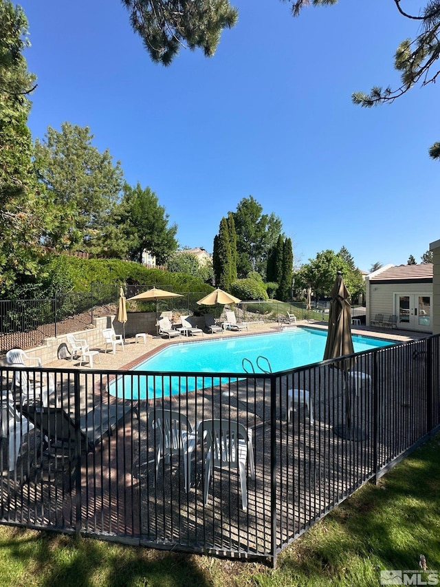 community pool featuring a patio and fence