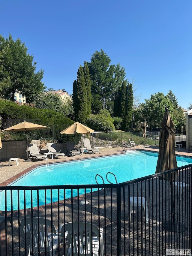 community pool featuring a patio and fence